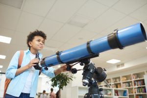 صبي أمريكي من أصل أفريقي مع تلسكوب