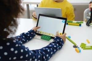 أطفال متعددي الأعراق في درس التكنولوجيا الروبوت على الكمبيوتر اللوحي